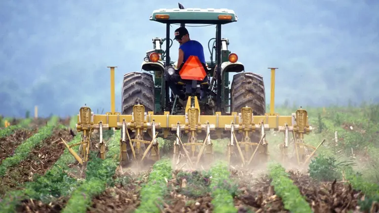 Imagen de archivo de un agricultor conduciendo un tractor