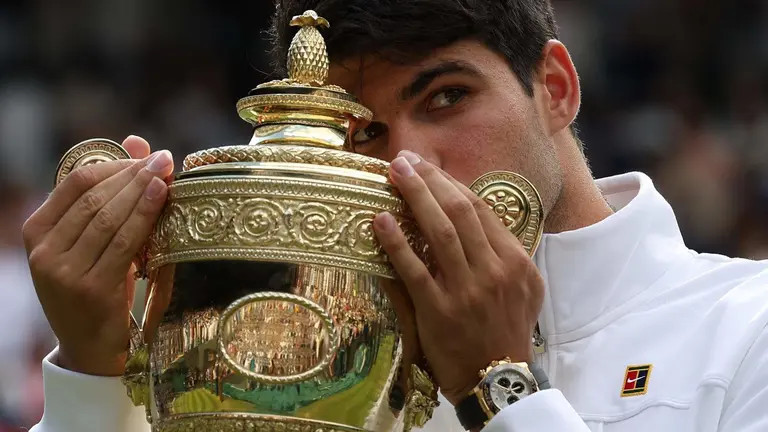 El murciano Carlos Alcaraz besa el trofeo tras vencer a Novak Djokovic en la final del torneo de Wimbledon (foto: EFE)